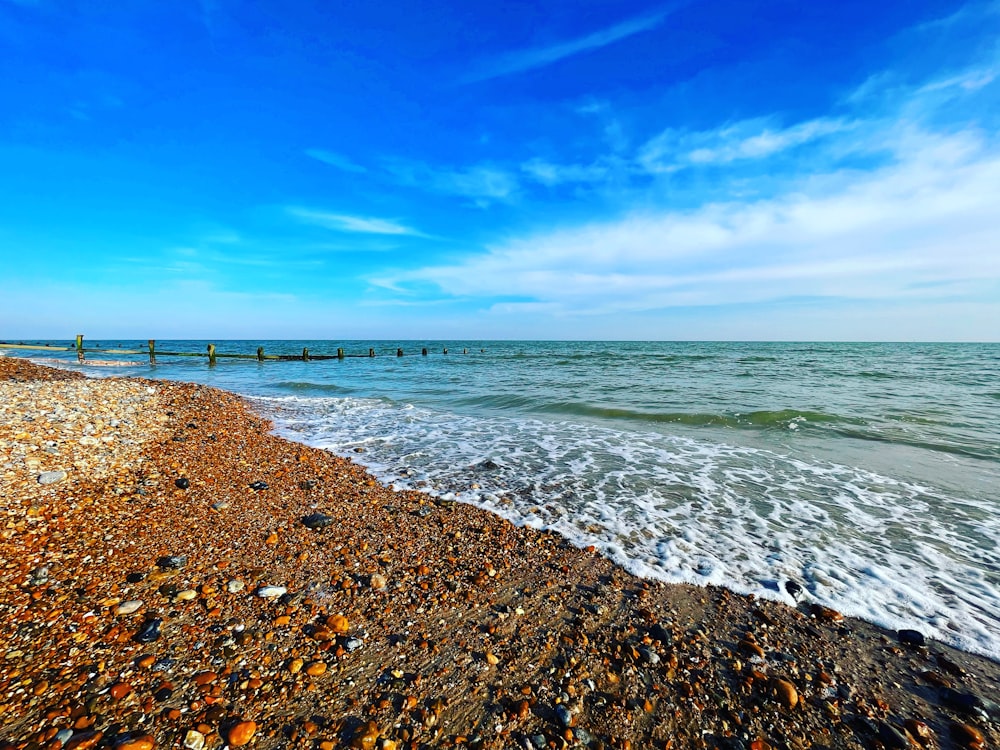 a sandy beach with waves coming in to shore