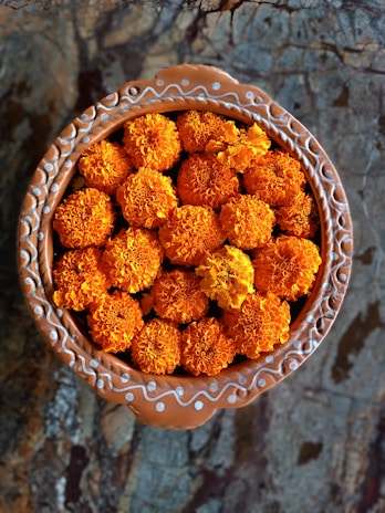 An elegant arrangement of handcrafted pottery and vibrant marigold flowers, symbolizing warmth and celebration.