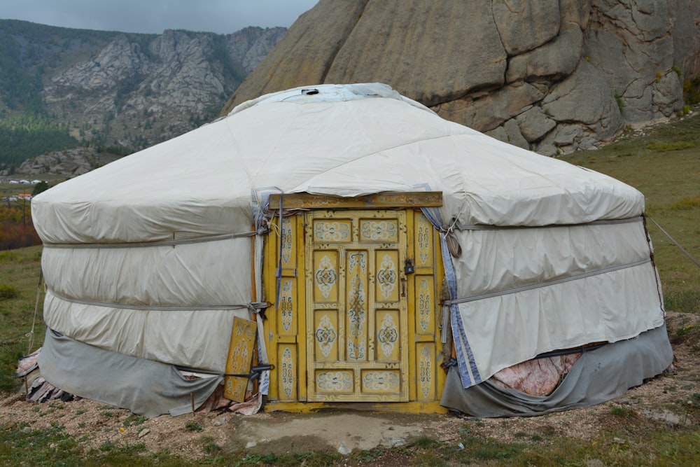 a yurt in the mountains with a yellow door