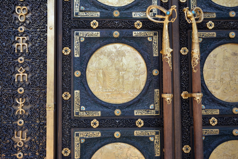 a close up of a metal door with gold decorations