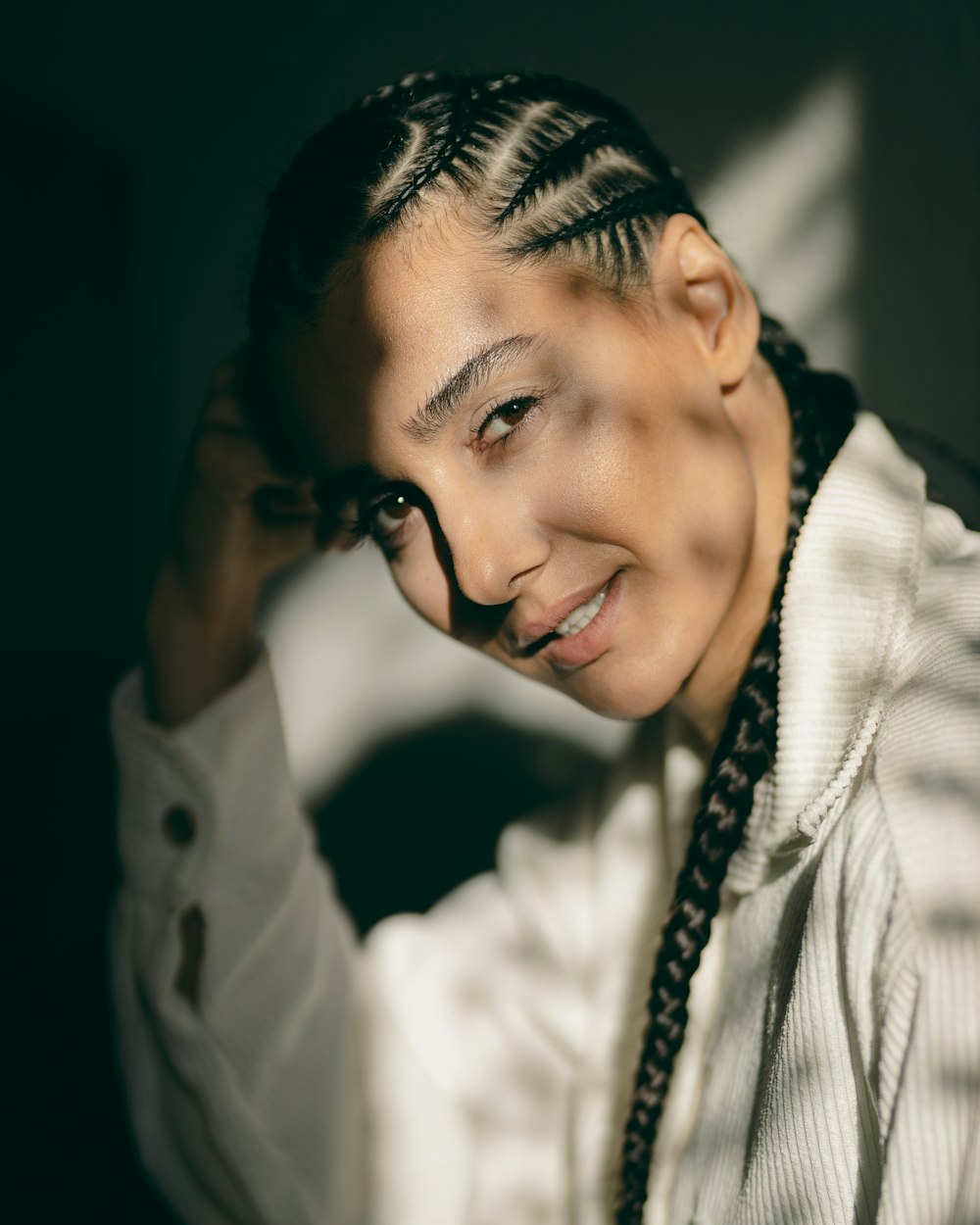 a woman with braids and a white shirt