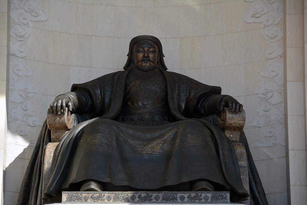 a statue of a man sitting in a chair