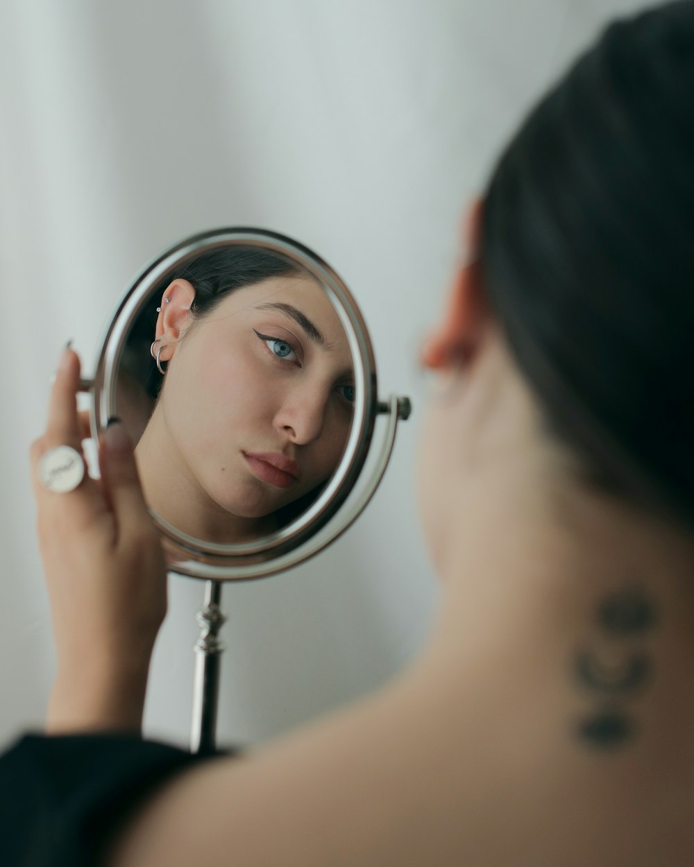 a woman looking at her face in the mirror