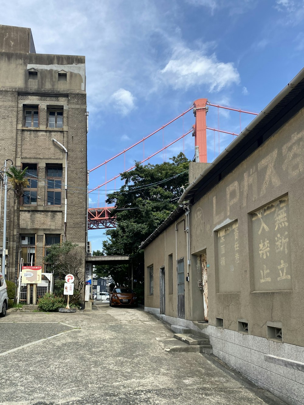 a street with a building and a bridge in the background