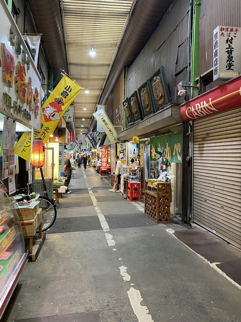 a narrow street with a lot of signs hanging from the ceiling