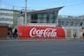 a large coca - cola truck is parked on the side of the road