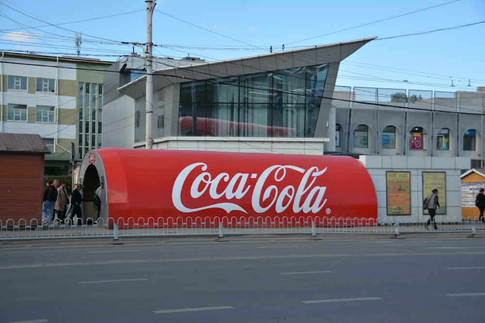 a large coca - cola truck is parked on the side of the road