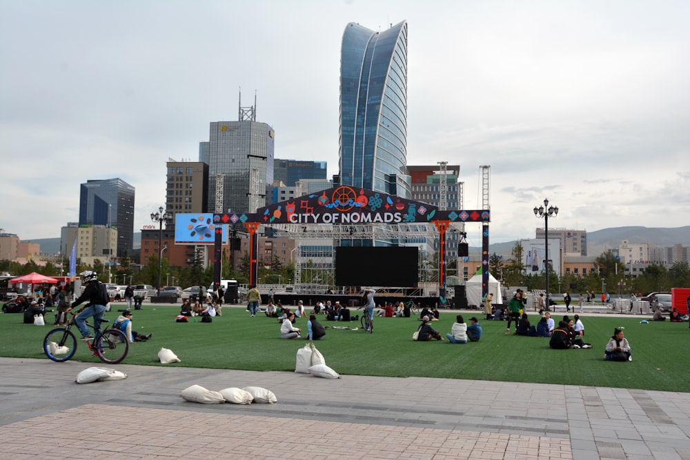 a group of people sitting on the grass in a park