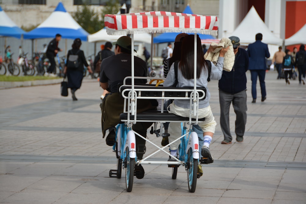 a man and a woman riding a bike with a canopy