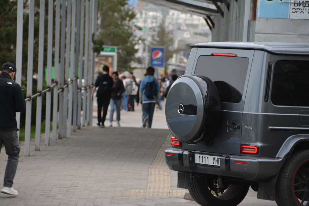 a man walking down a sidewalk next to a car