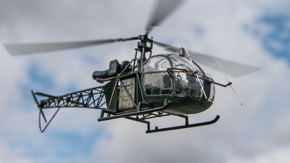 a helicopter flying through a cloudy blue sky