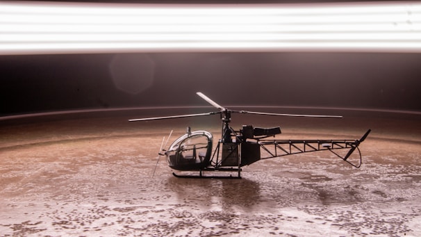 A vibrant toy helicopter resting on a wooden table with a blurred background