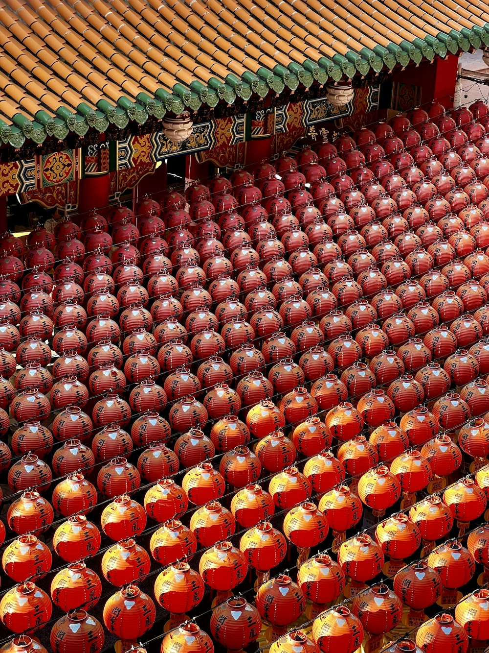 a large number of red and yellow vases in front of a building