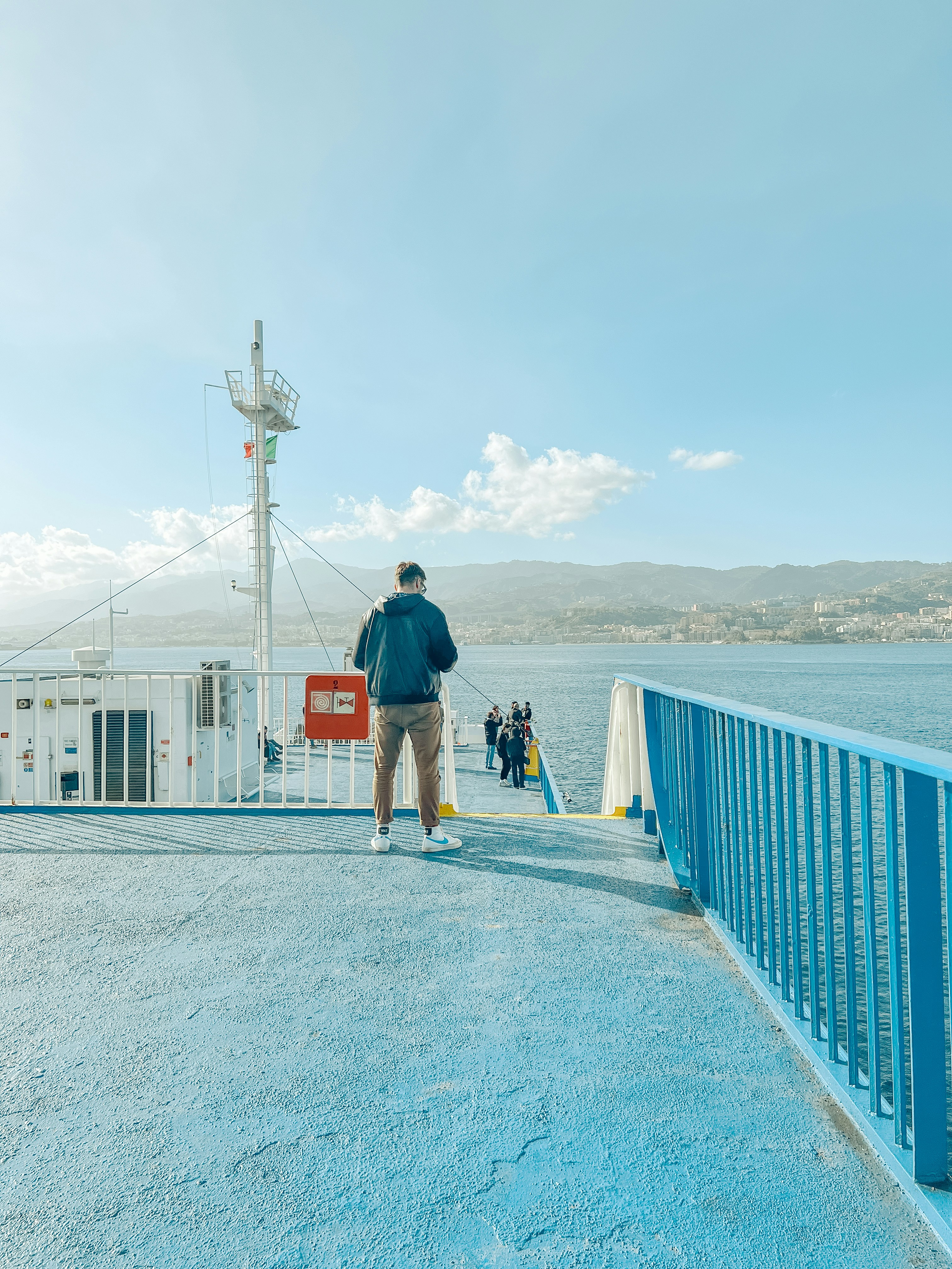 a man walking across a bridge next to a body of water