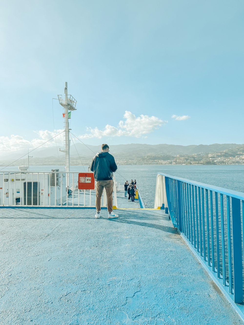 a man walking across a bridge next to a body of water