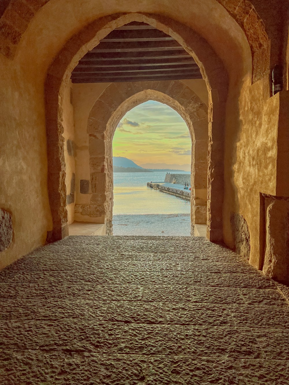 a tunnel leading to a beach with a view of the ocean