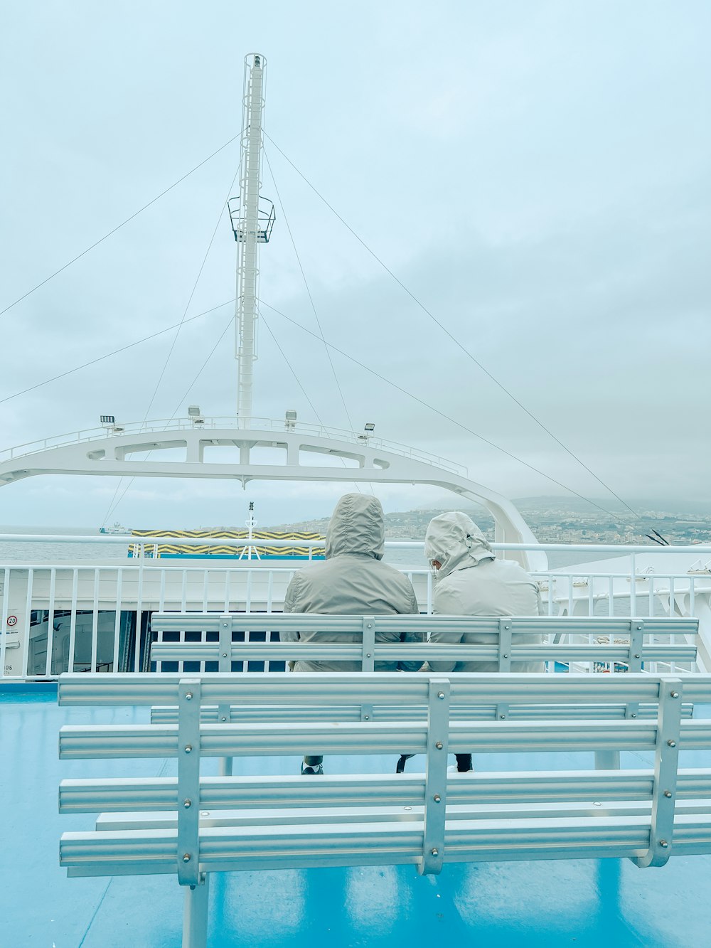 two people sitting on a bench on a boat