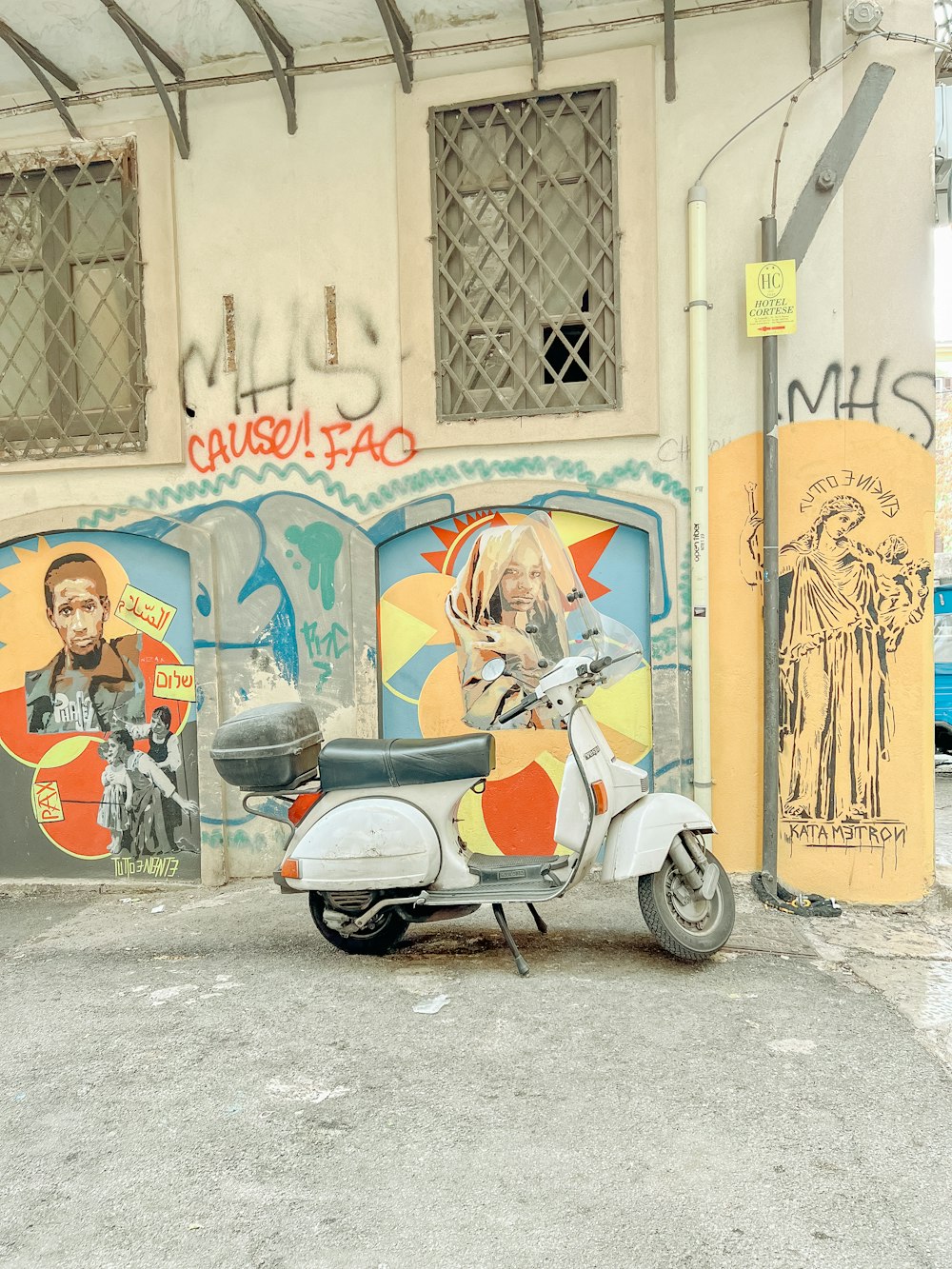 a scooter parked in front of a building with graffiti on it