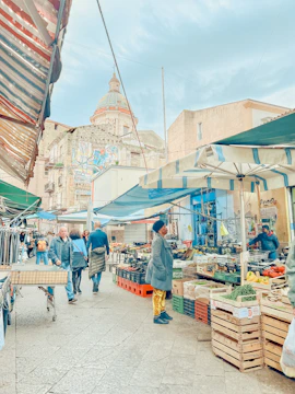 A vibrant street market bustling with colorful stalls and local architecture.
