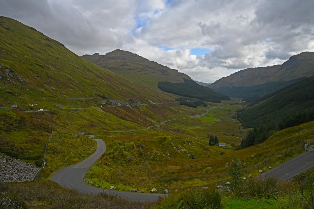 a winding road winding through a lush green valley