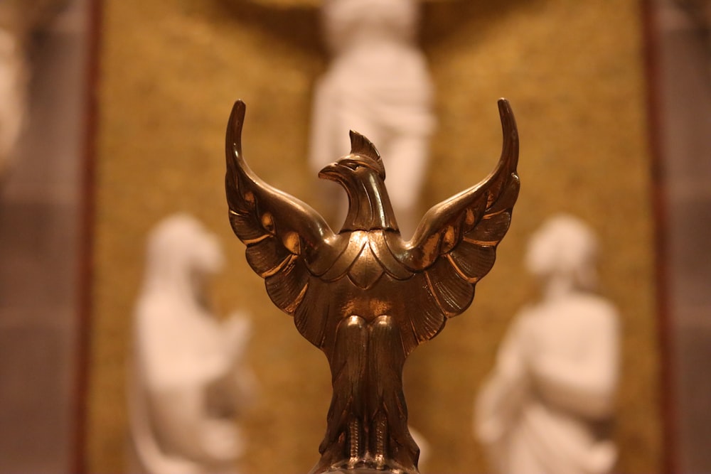 a golden statue of a bird on a pedestal