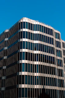 A grand view of a modern high-rise building constructed by PT Sumber Bahagia Nausantara, showcasing sleek navy and gold accents.