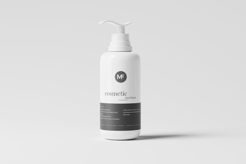 A white plastic pump bottle labeled as a cosmetic mockup stands against a neutral gray background. The bottle features a minimalist design with the text 'cosmetic mockup' printed in black. The pump dispenser is white, matching the bottle's color.