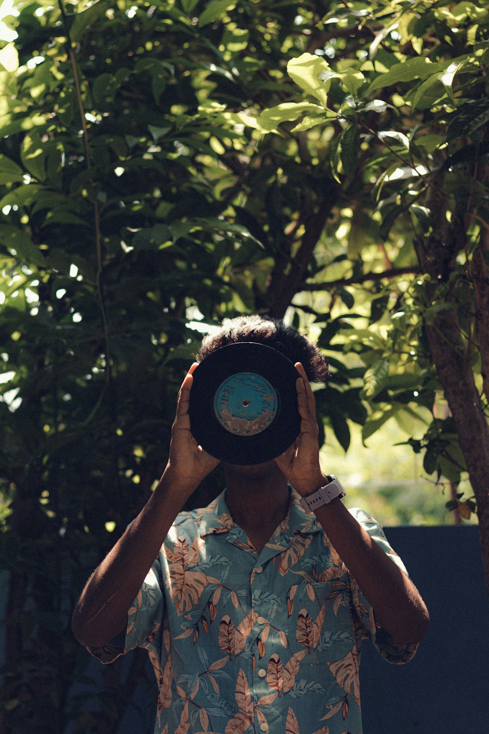 a man holding up a hat in front of his face