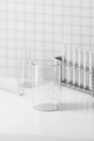 Close-up of clear borosilicate glass beakers and flasks arranged neatly on a lab bench.