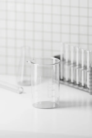 Close-up of clear borosilicate glass beakers and flasks arranged neatly on a lab bench.