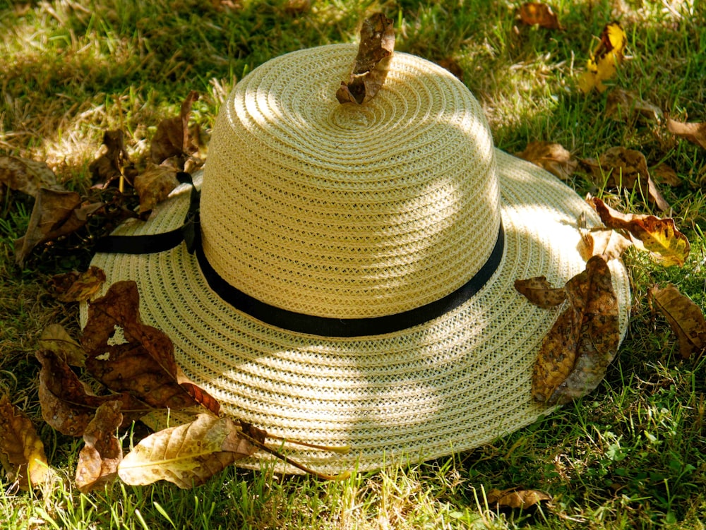 a white hat sitting on top of a lush green field