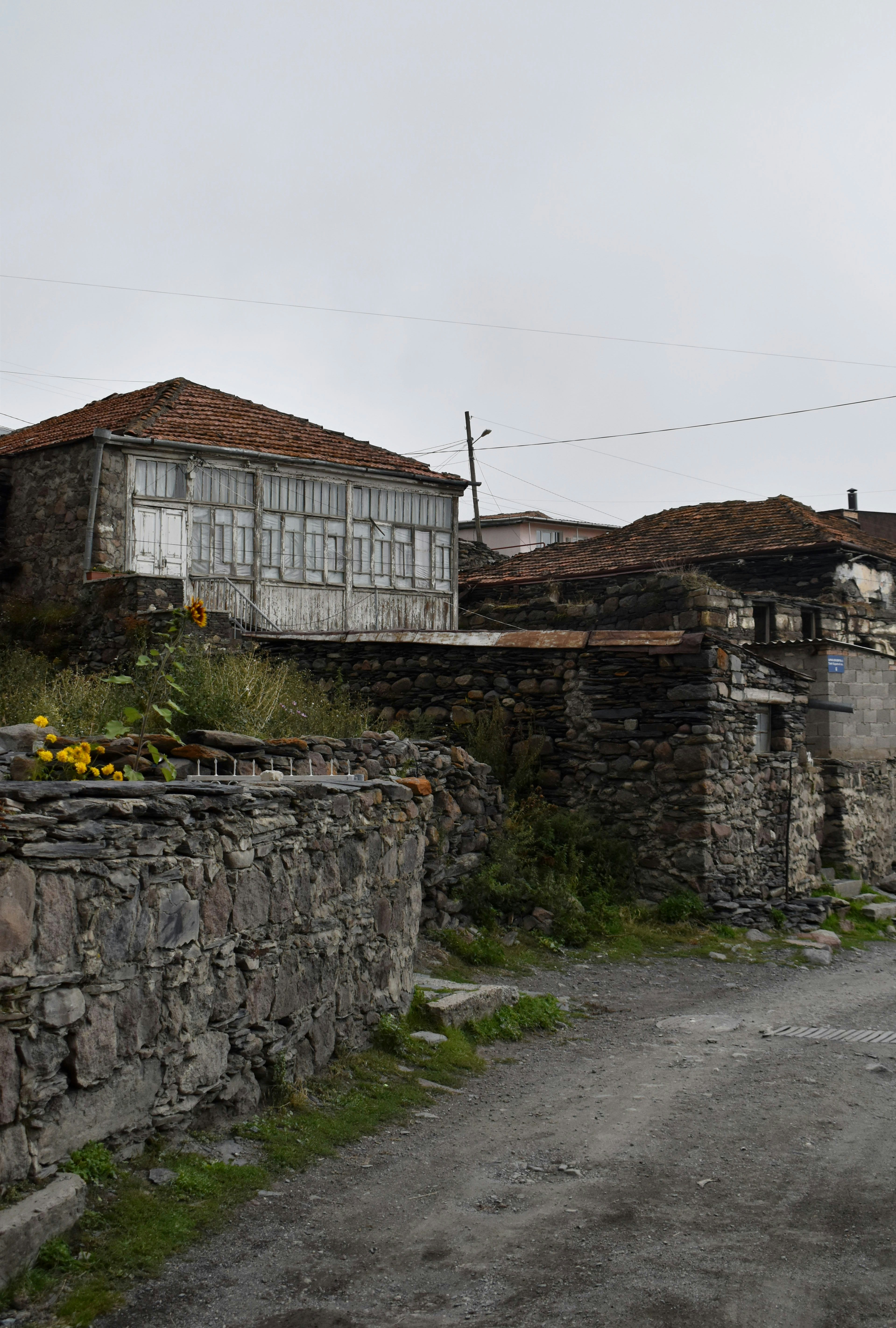 a stone wall with a building in the background