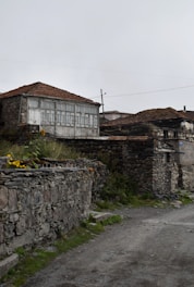 a stone wall with a building in the background