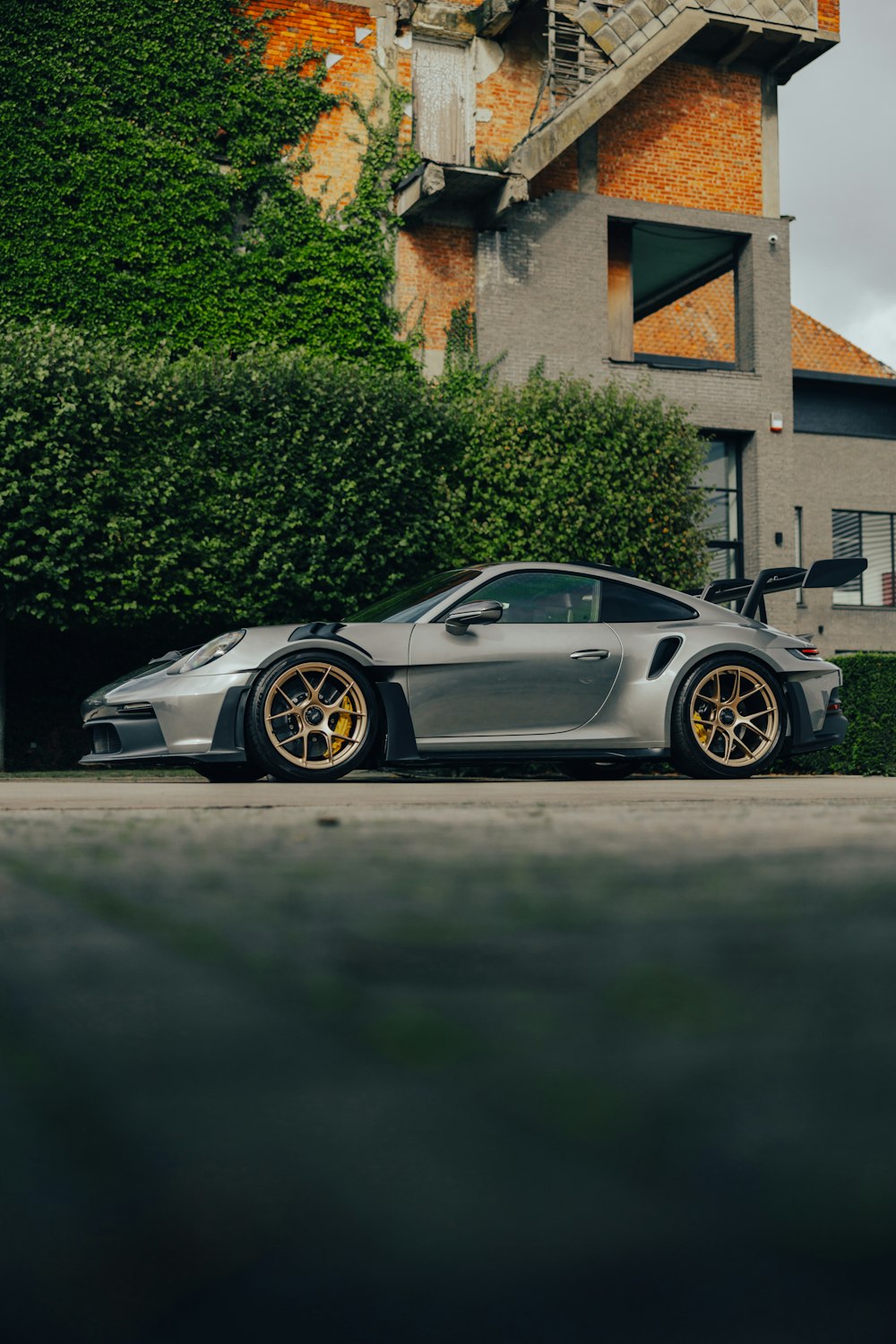 a silver sports car parked in front of a building