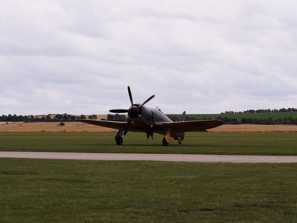 a small propeller plane on a runway in a field
