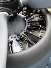 A detailed view of an airplane radial engine showcasing its intricate mechanical components, including metal cylinders, pipes, and a large propeller hub.