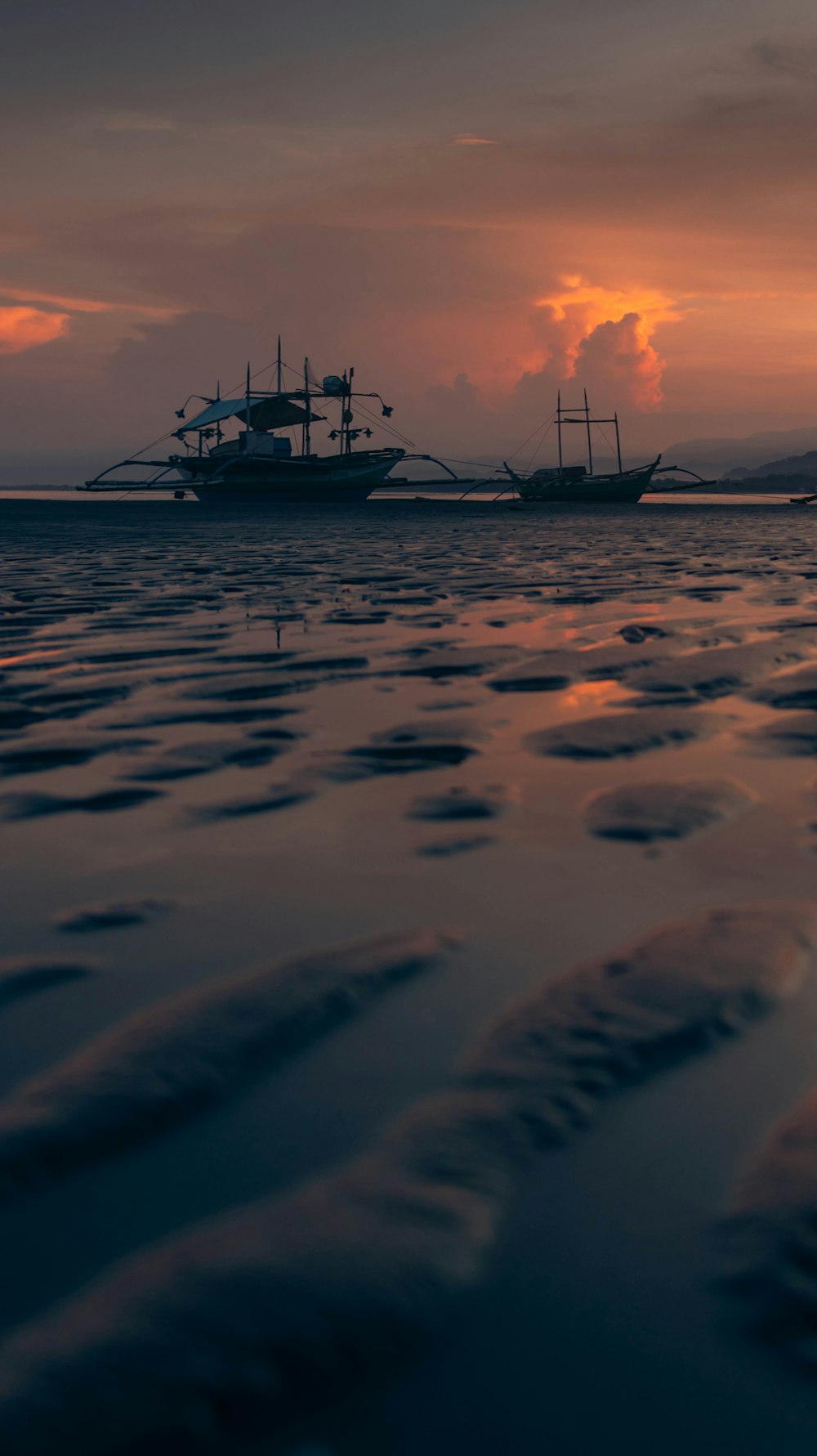 a couple of boats floating on top of a body of water