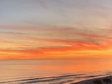 A vibrant beach sunset with travelers enjoying the warm sand and calm waves