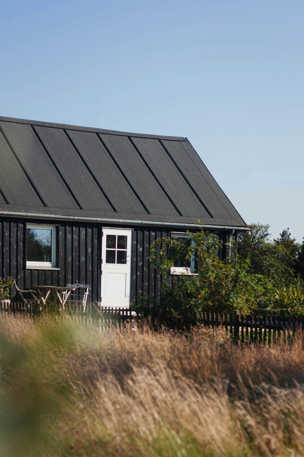 a small black house with a white door