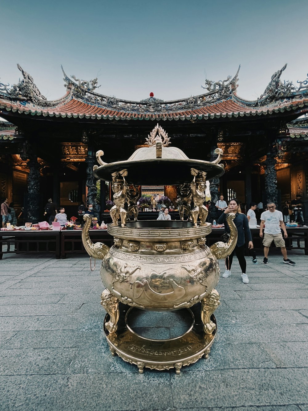 a large golden vase sitting in front of a building