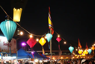 A vibrant night market in Taiwan glowing under colorful lanterns.