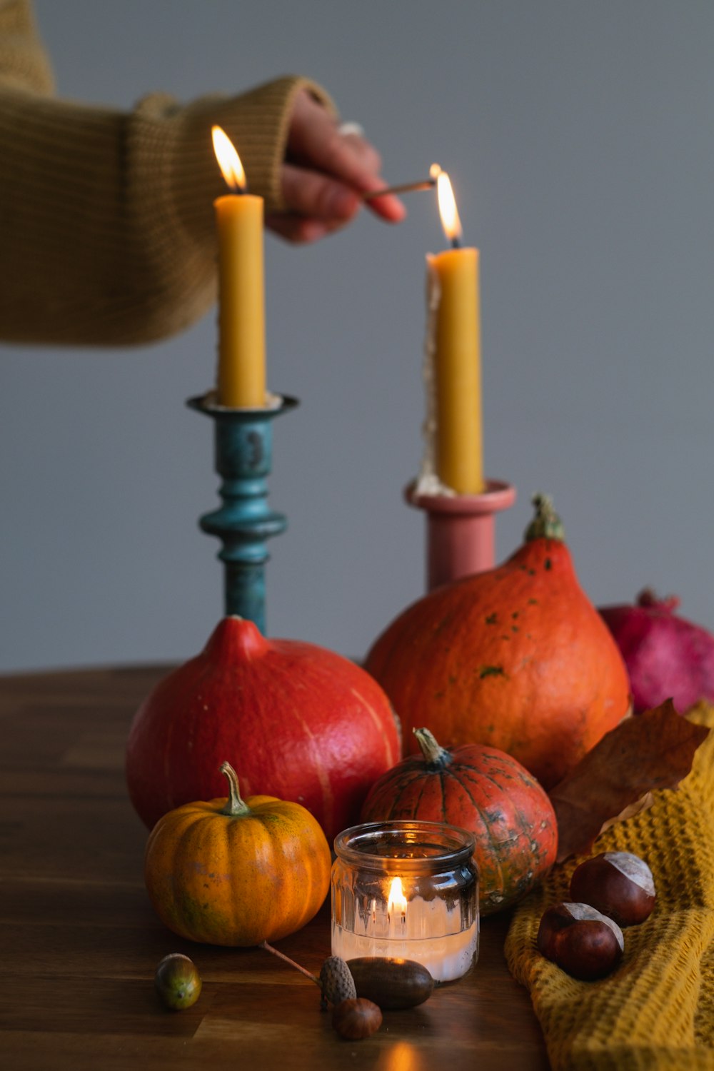 a person lighting a candle on a table