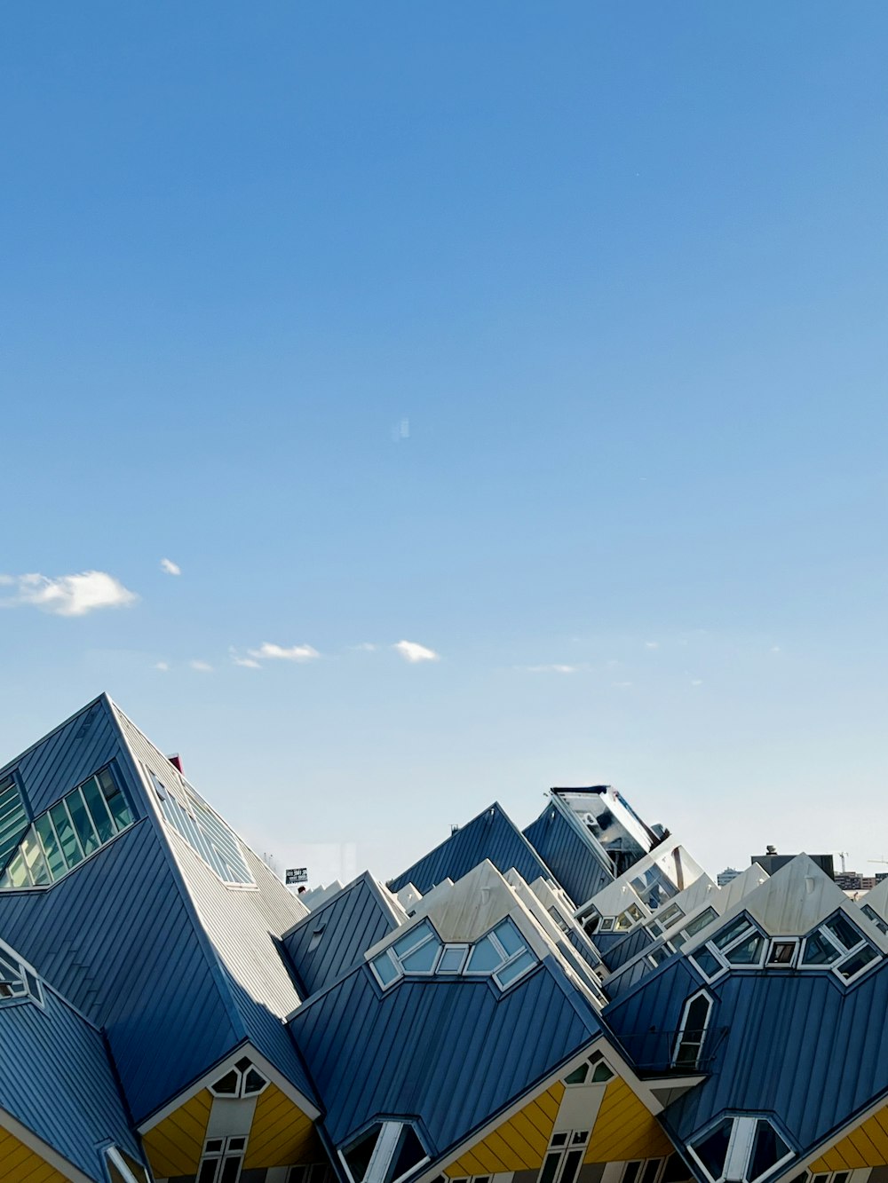 a blue and yellow building with a plane flying in the sky