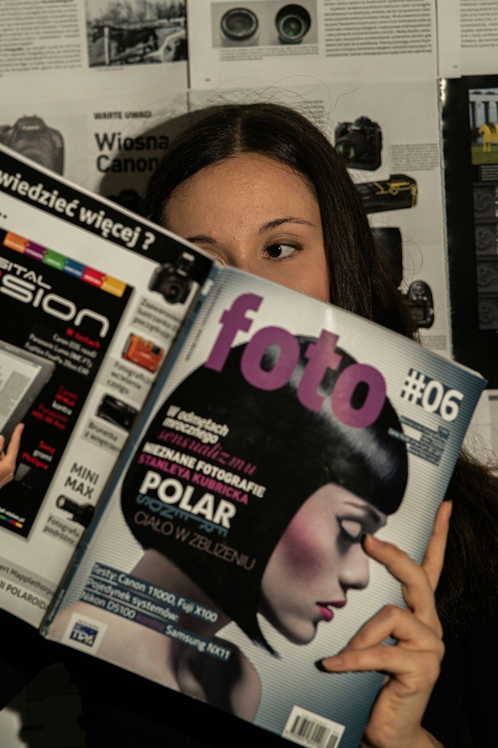 a woman holding a magazine in front of her face