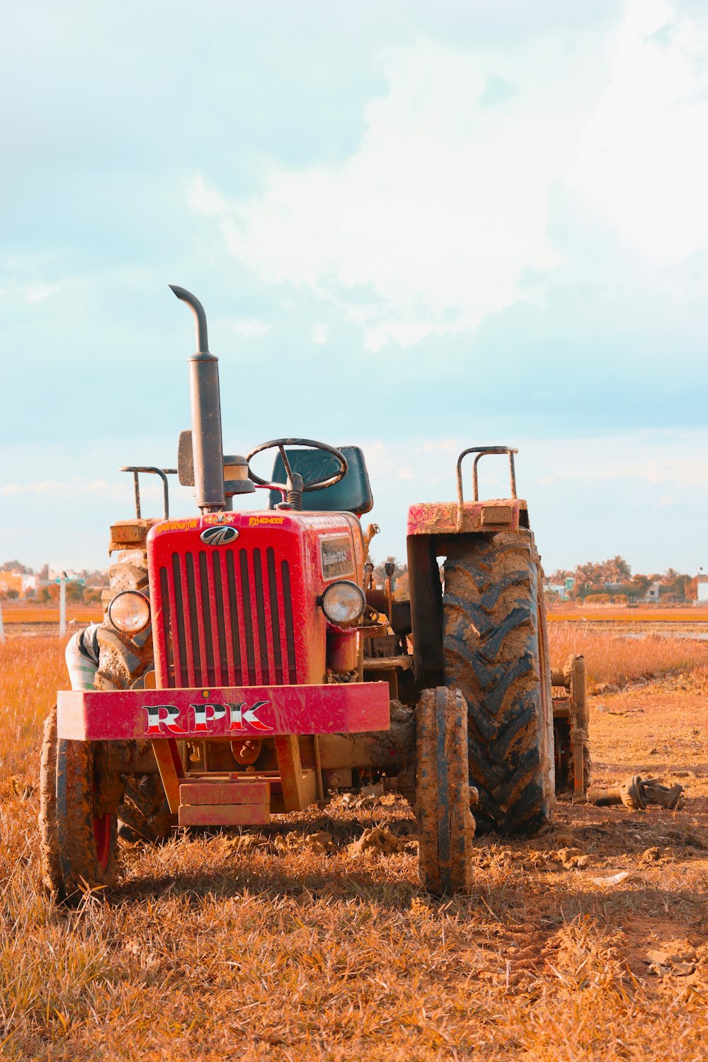 Un tractor rojo está estacionado en un campo