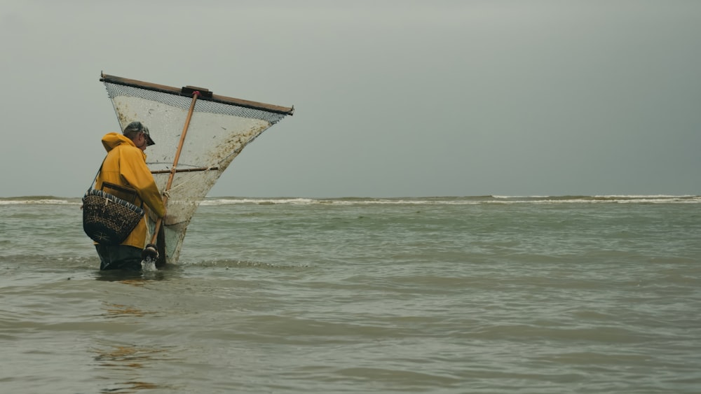 a man standing in the ocean holding a fishing net