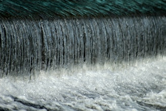 a close up of water flowing over a dam