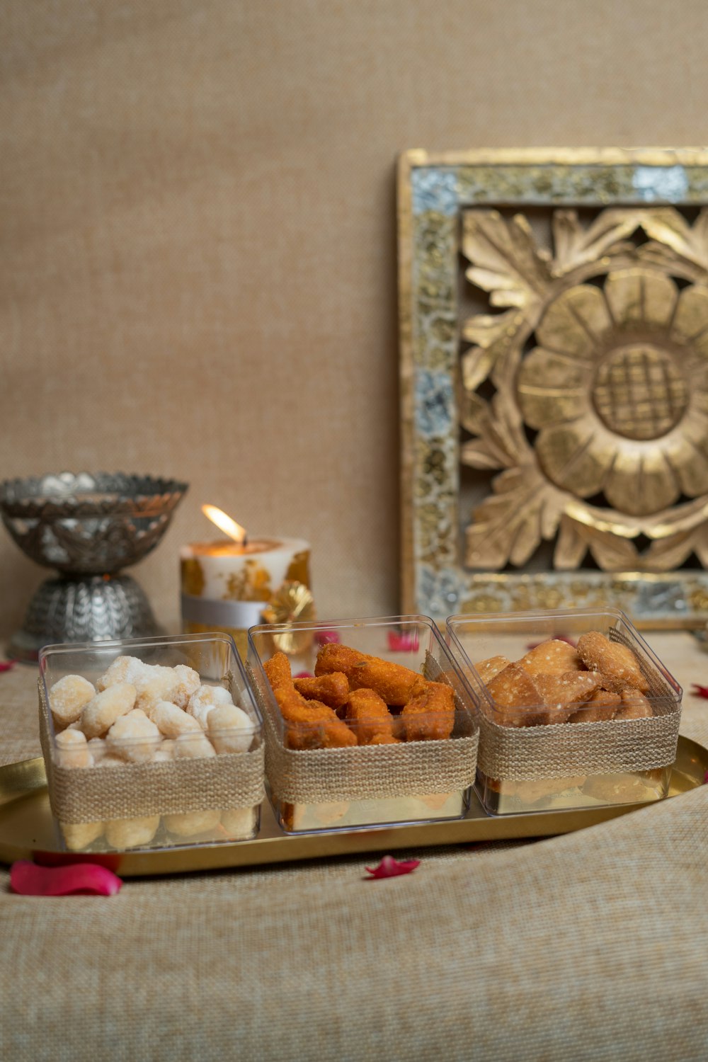 a table topped with trays of food next to a candle