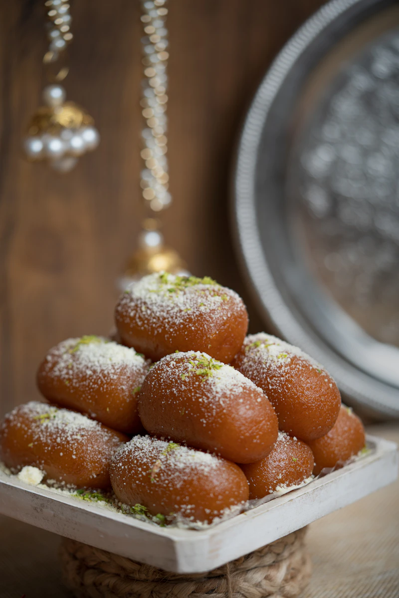 A pile of round golden Indian sweets on a white plate