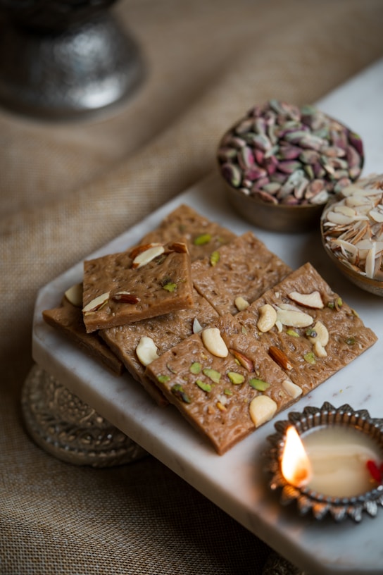 Close-up of a skilled artisan handcrafting kaju katli with delicate precision, surrounded by fresh nuts and saffron strands.